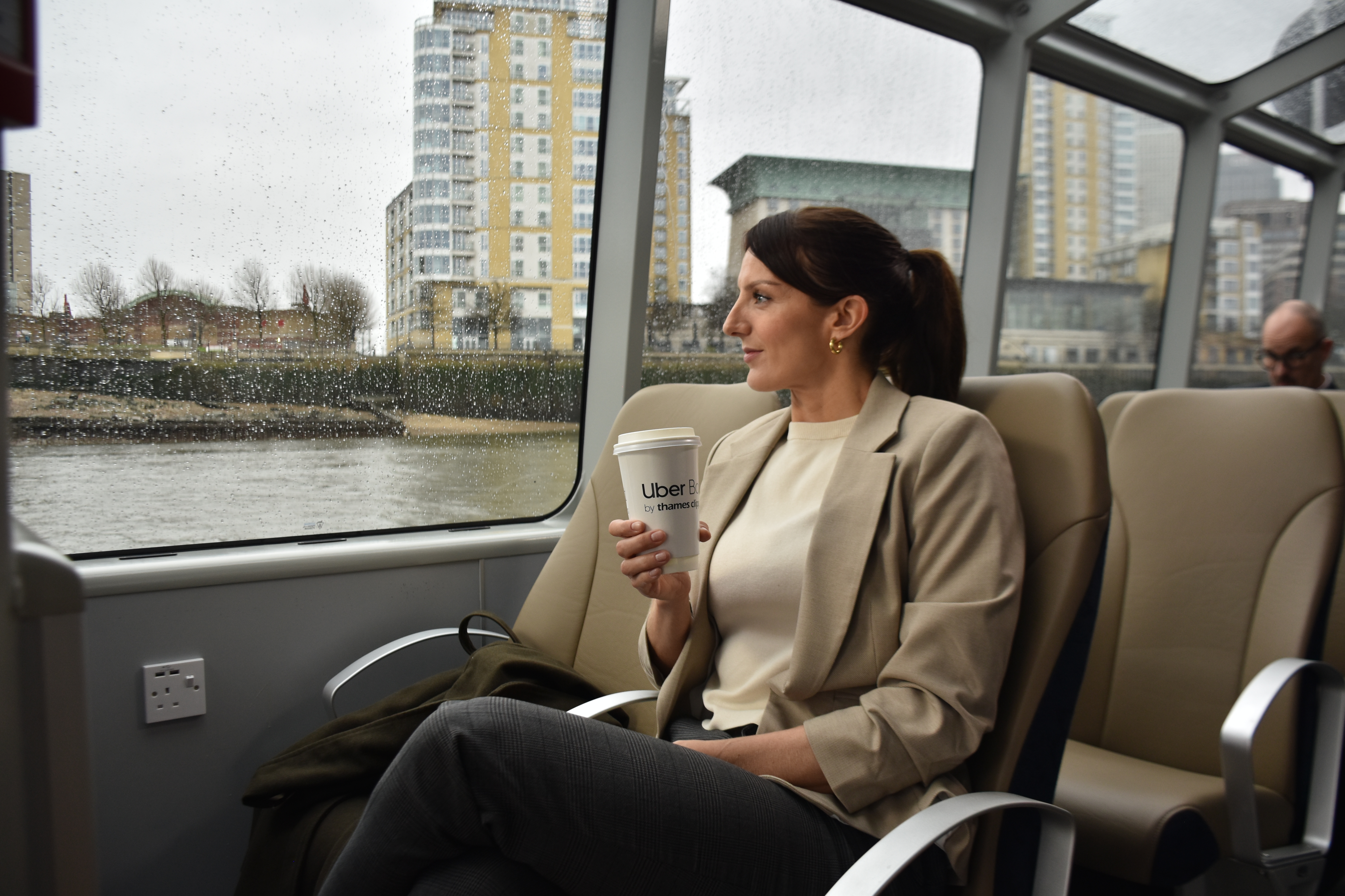Commuter with coffee on rainy day