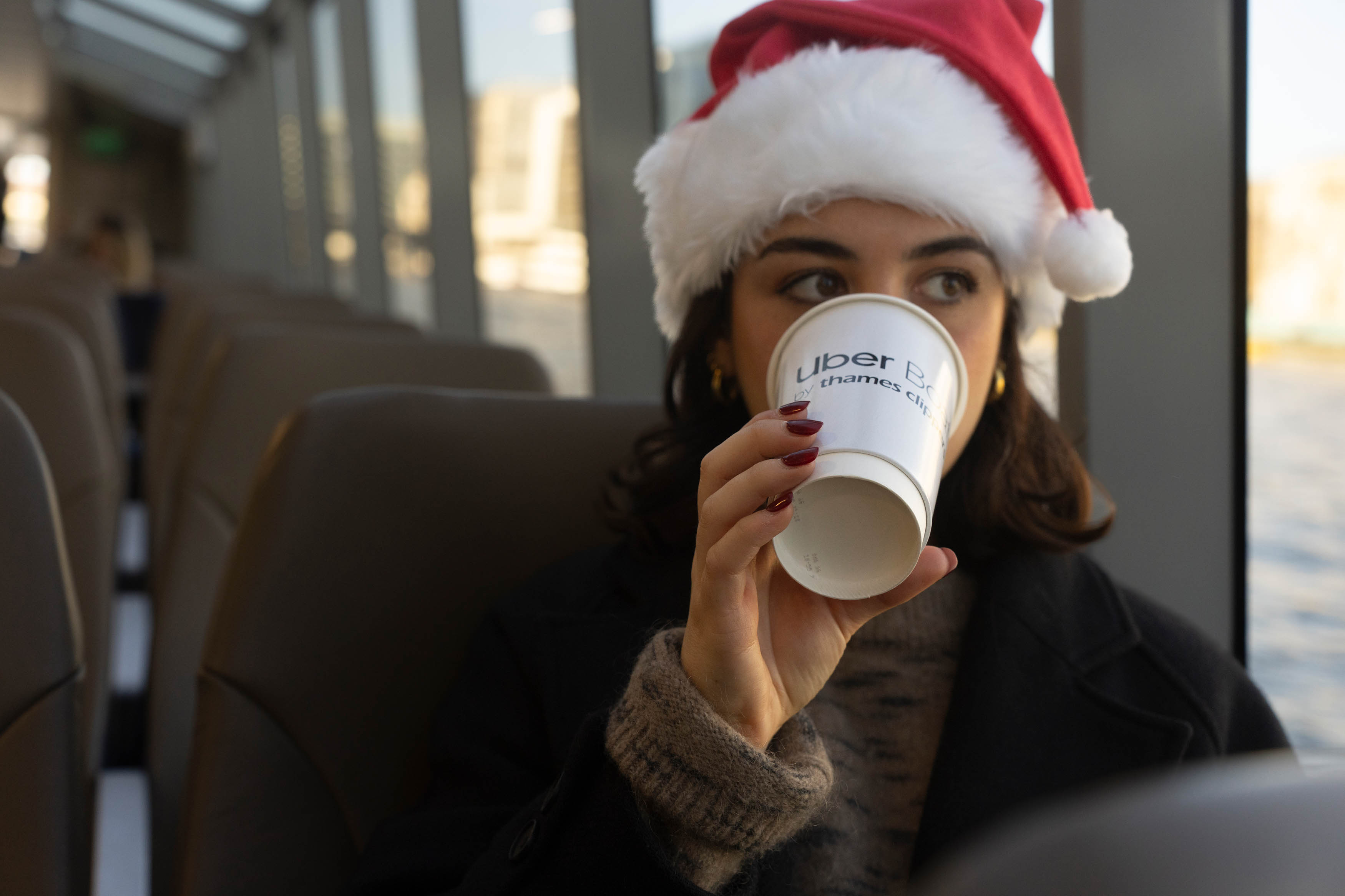 Girl with Christmas hat drinking hot drink