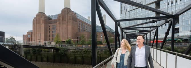 Couple walking down Battersea Power Station pier
